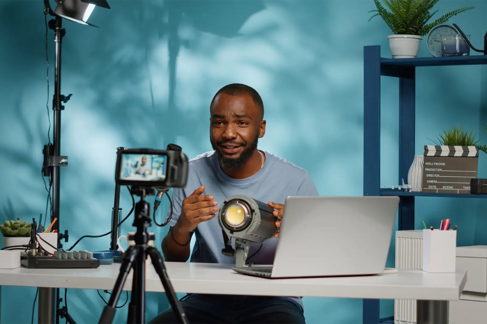 A person filming an advert video focused on video design, creatively explaining concepts with a modern setup including a laptop and camera.